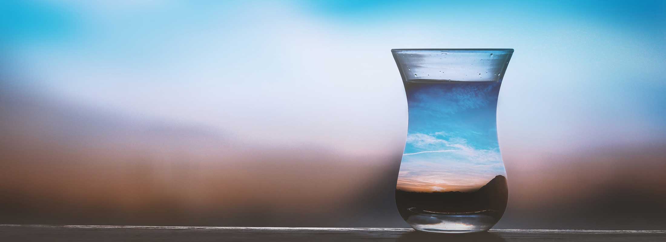 Water glass reflecting the landscape background