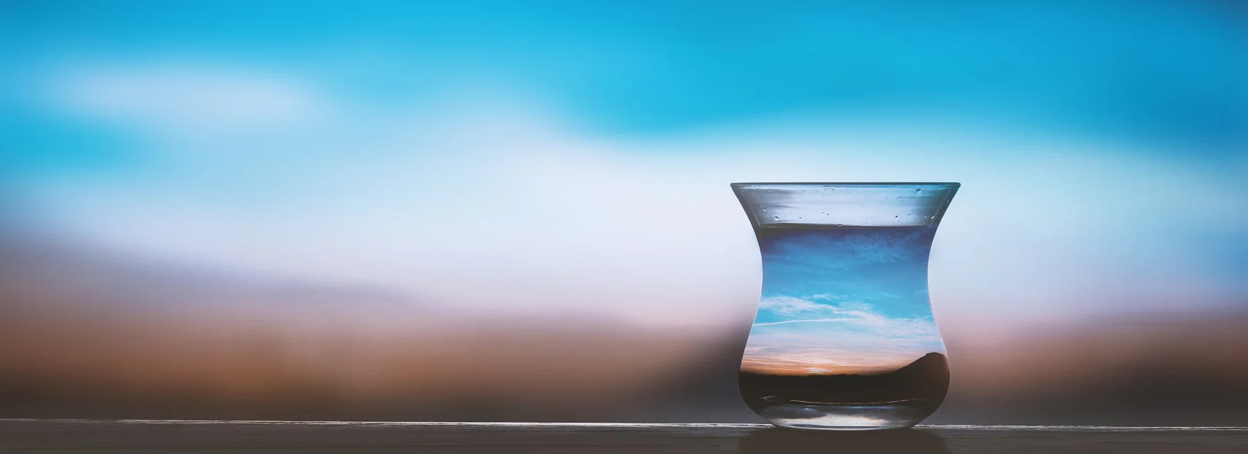 Water glass reflecting the landscape background